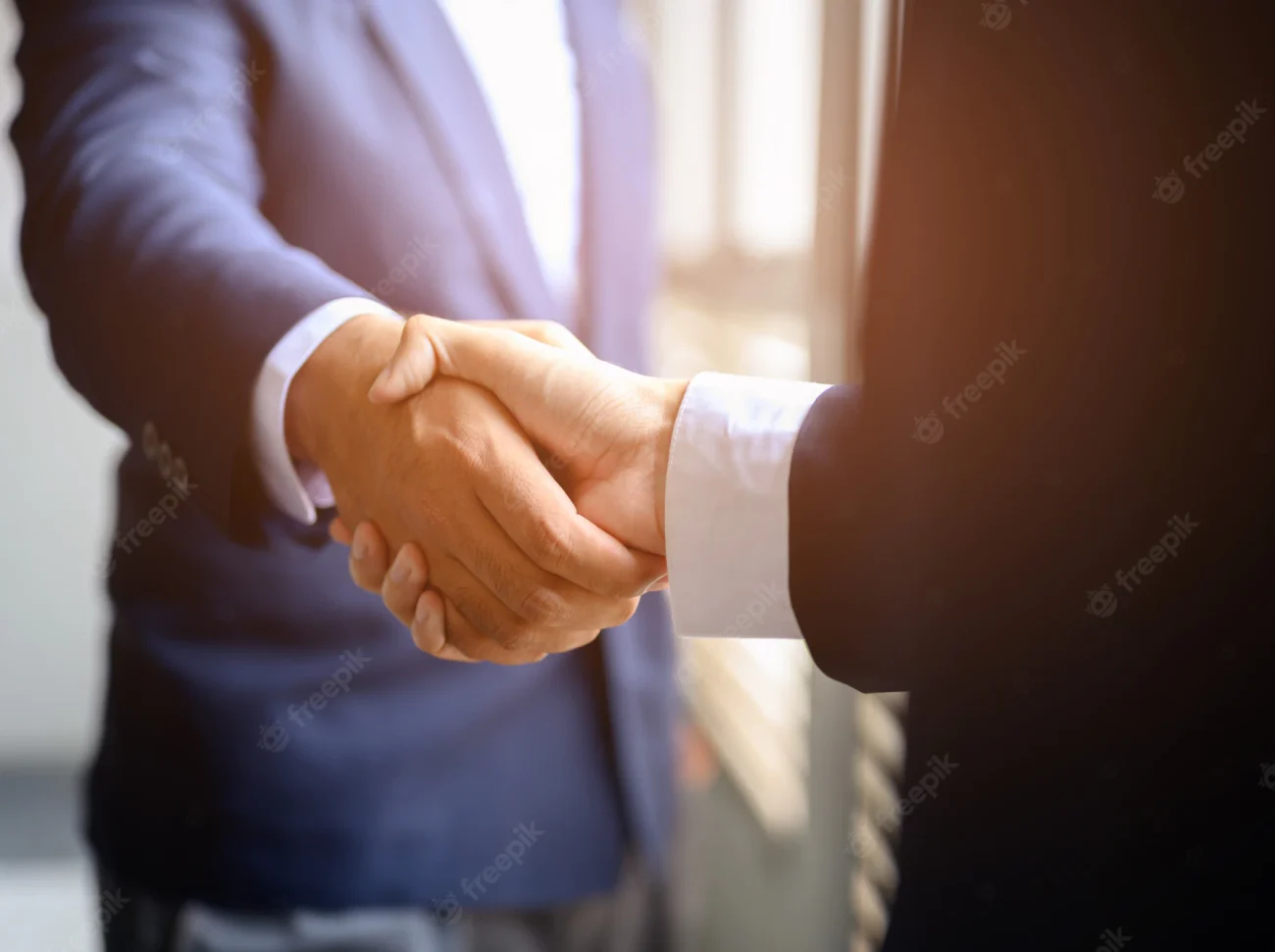 two-businessmen-join-hands-business-cooperation_43157-779